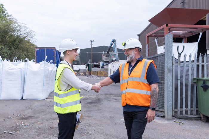 two people in high visibility jackets shaking hands